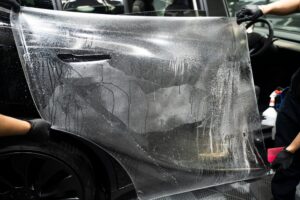 Professionals applying paint protection film.